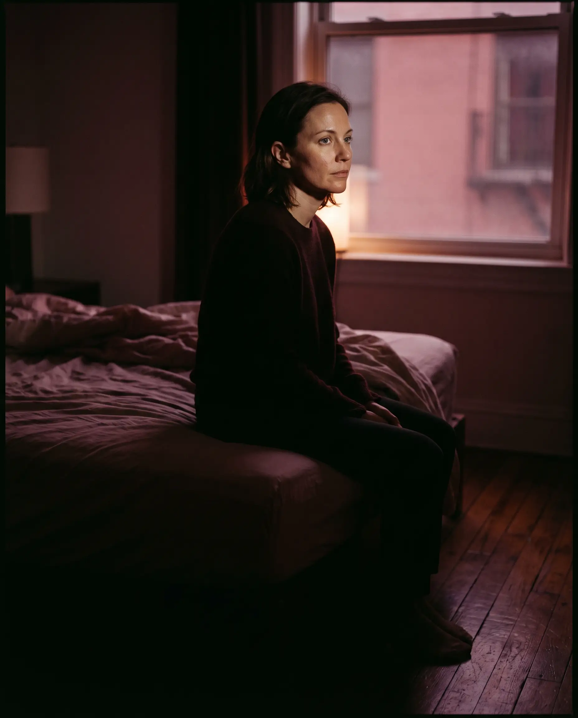 Two people seated in composed conversation in warm architectural light